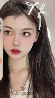 拿着手机自拍，头发戴着白色蝴蝶结发饰