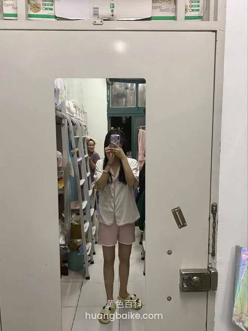 门缝里举手机自拍，身后有人走动
