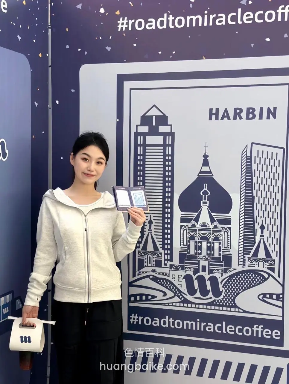 咖啡店活动墙前，手持门票和杯子