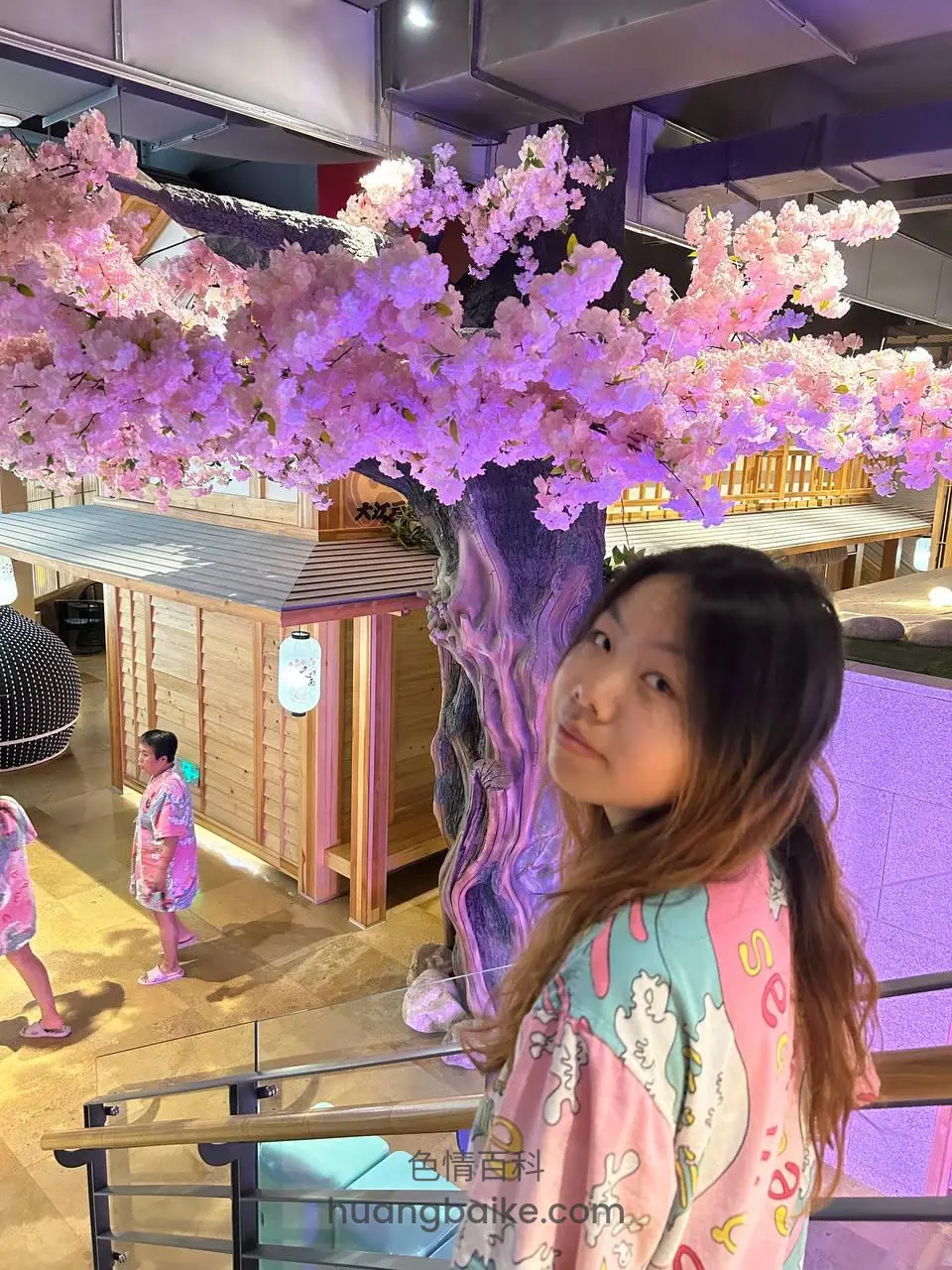 商场樱花树下，身后木屋和人