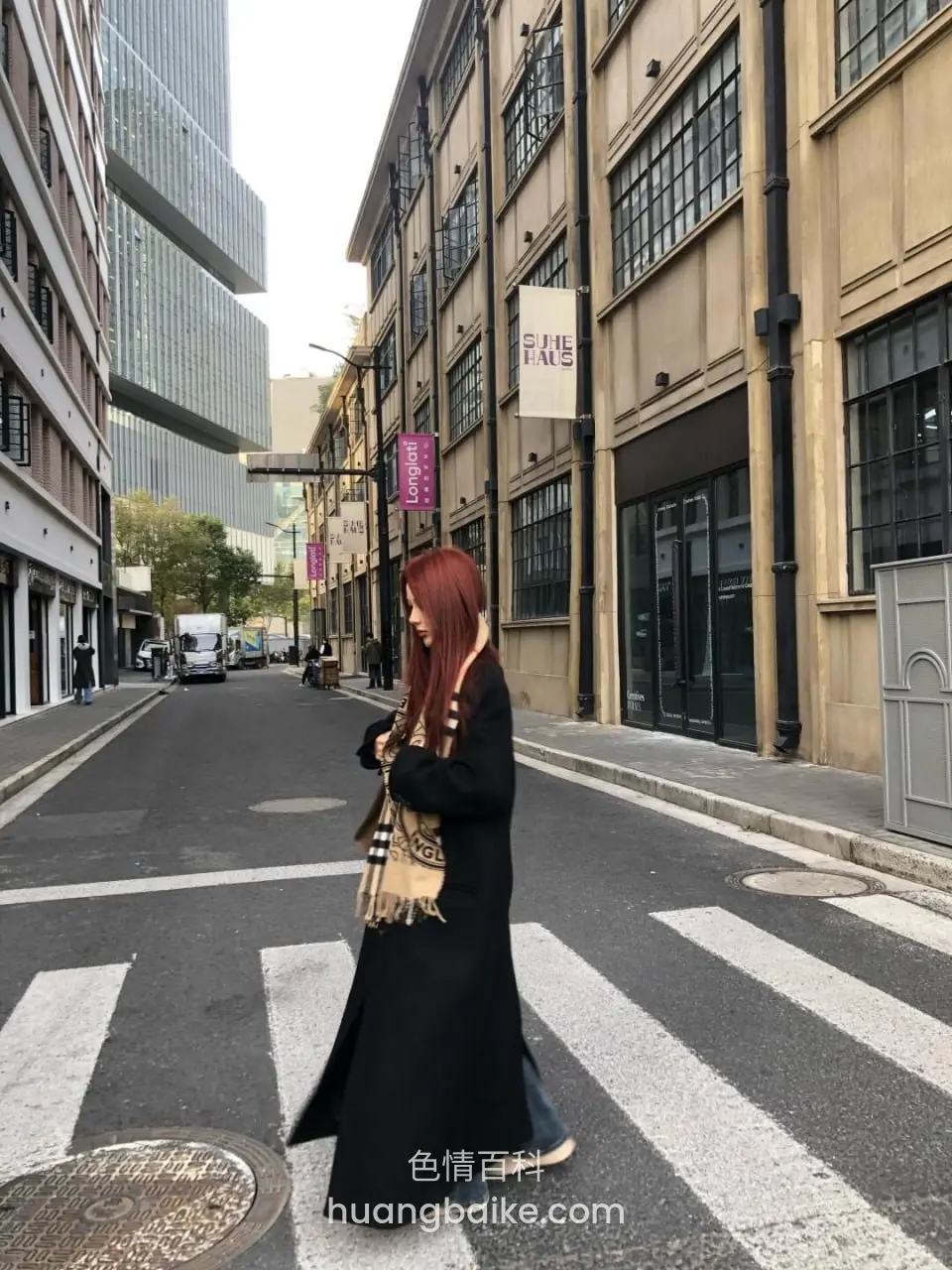 过斑马线，街边建筑挂着普拉达招牌