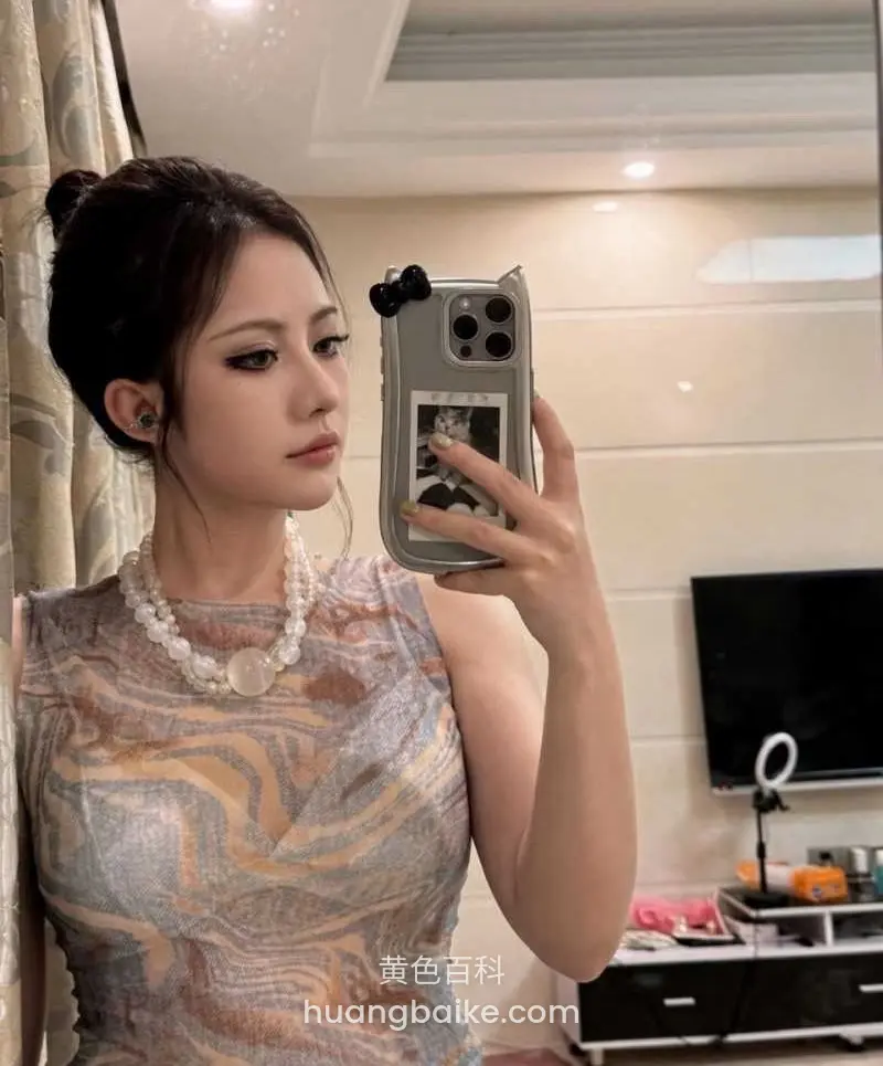 镜子前举手机自拍，身后电视柜