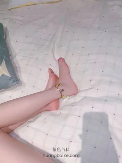 床上伸着腿脚腕戴饰品，镜头对着脚