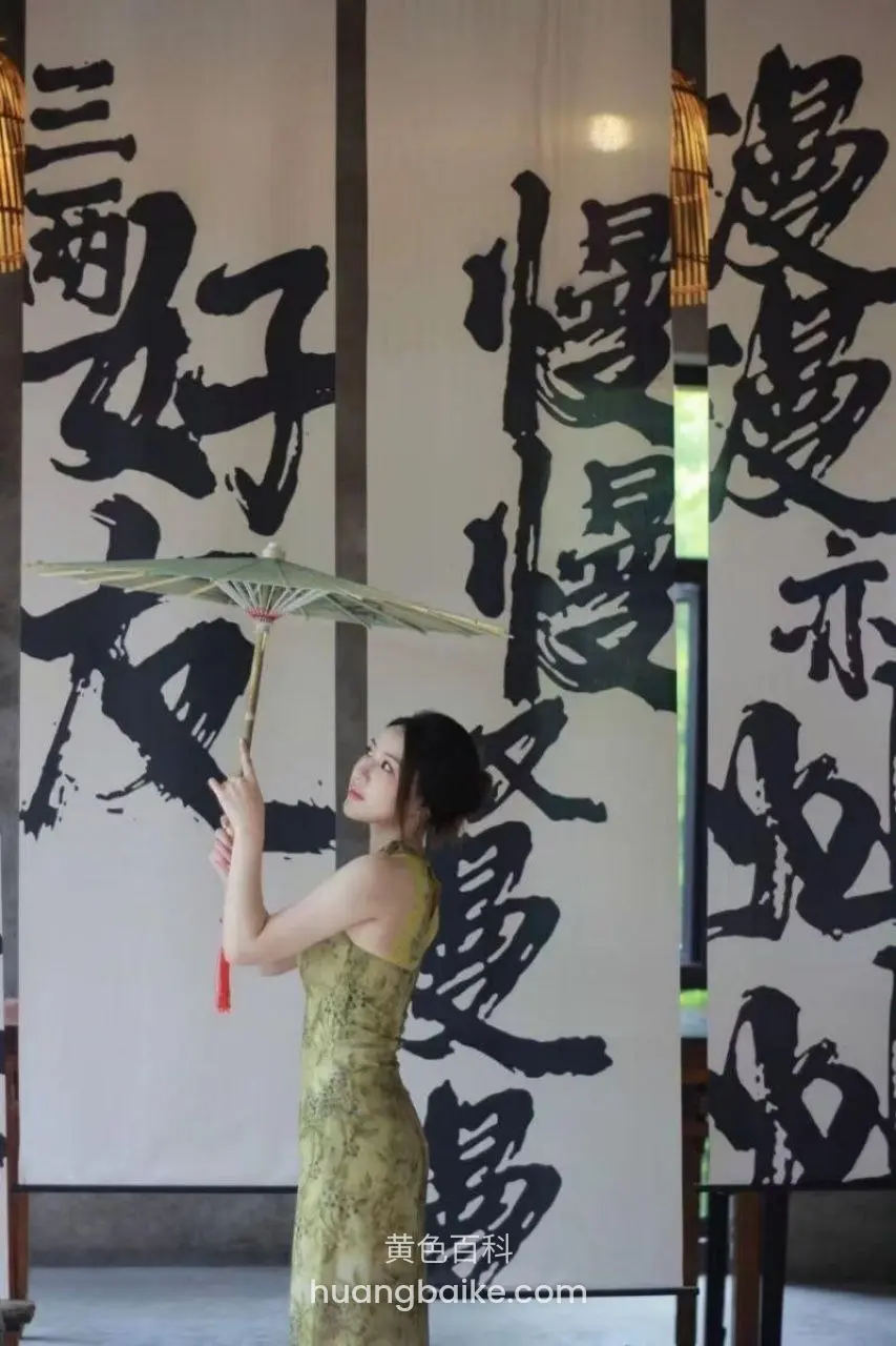 大书法字幅前，举着纸伞仰头看