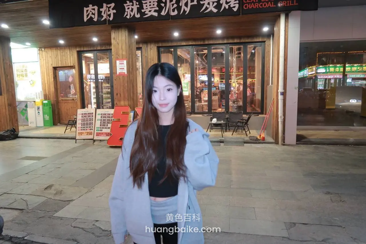 店门口站着看镜头，招牌写肉好就要泥炉炭烤