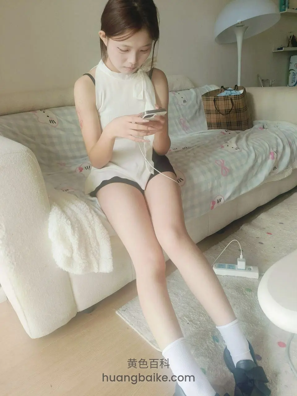手机和耳机线，手指在屏幕上
