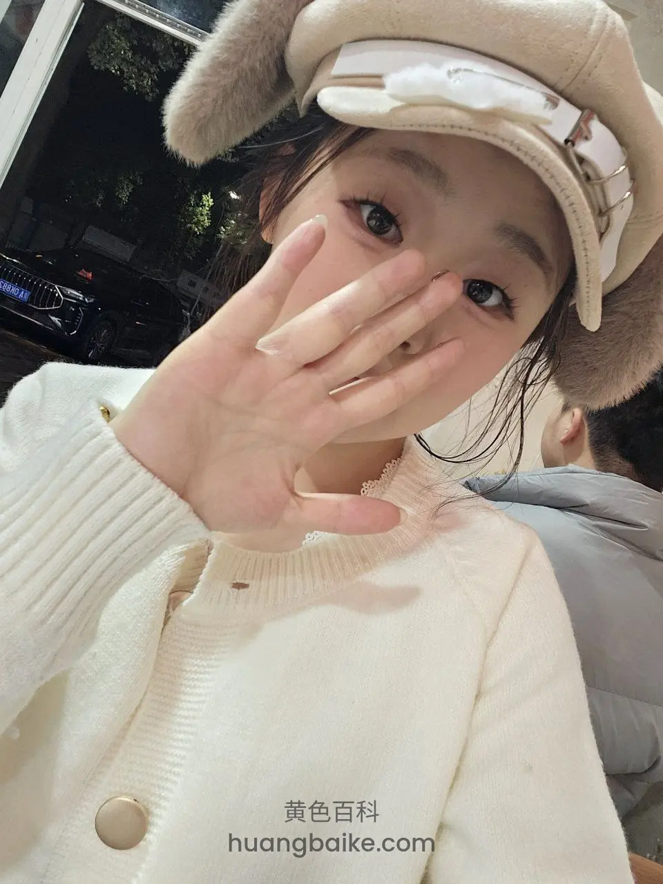 举手挡脸自拍，晚上街边