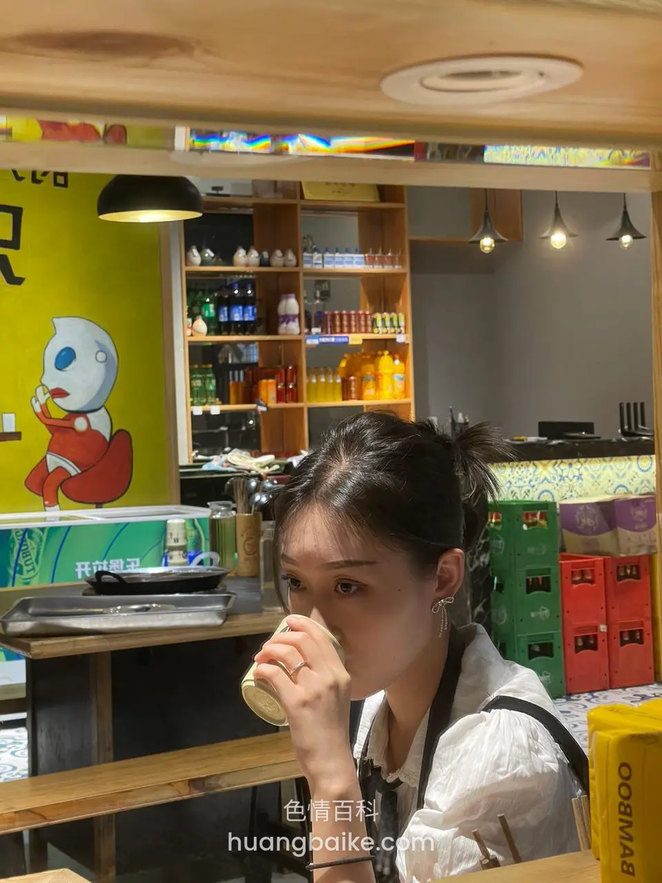 店里喝罐装饮料，身后货架和黄墙