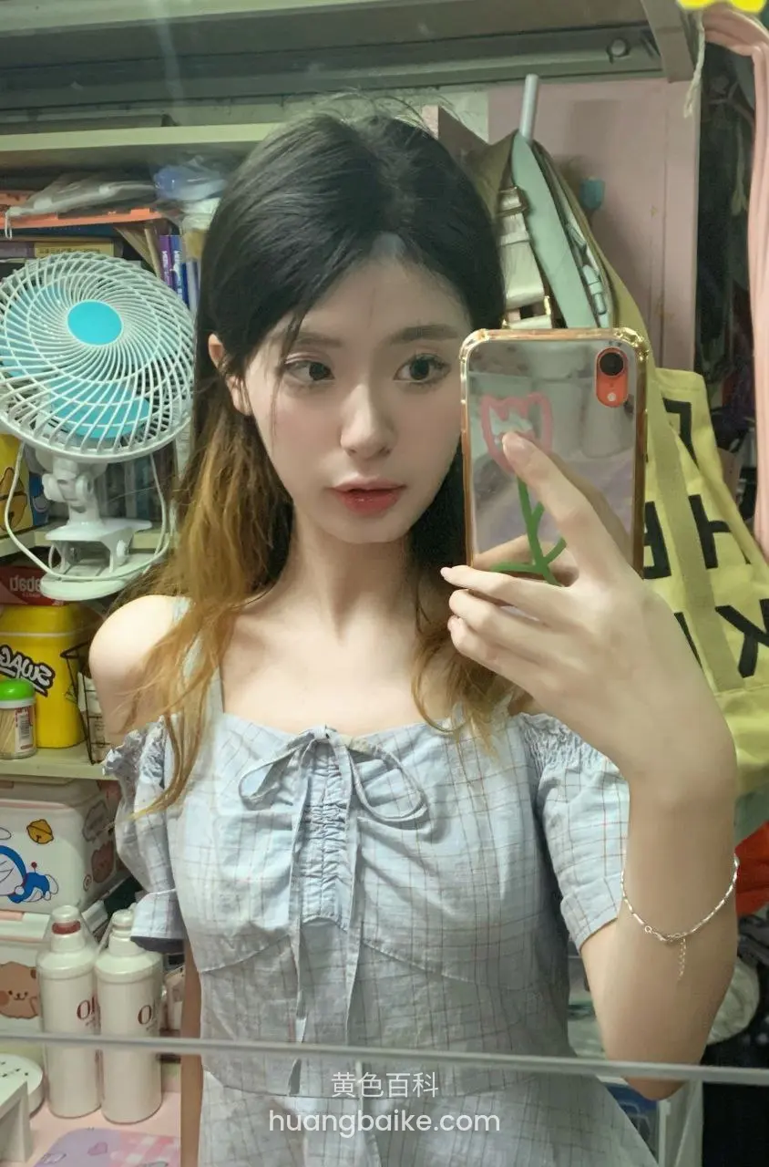 杂物间里拿着手机自拍，身后电扇和货架