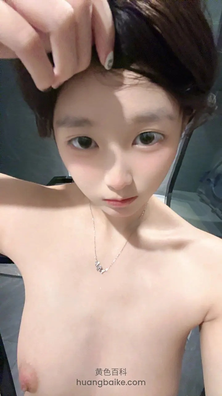 浴室镜子前举手撩头发，脖子戴着项链