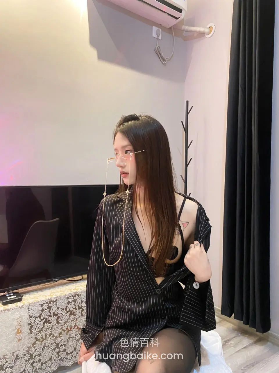 坐在电视柜前拉开条纹衬衫，露出胸前链子