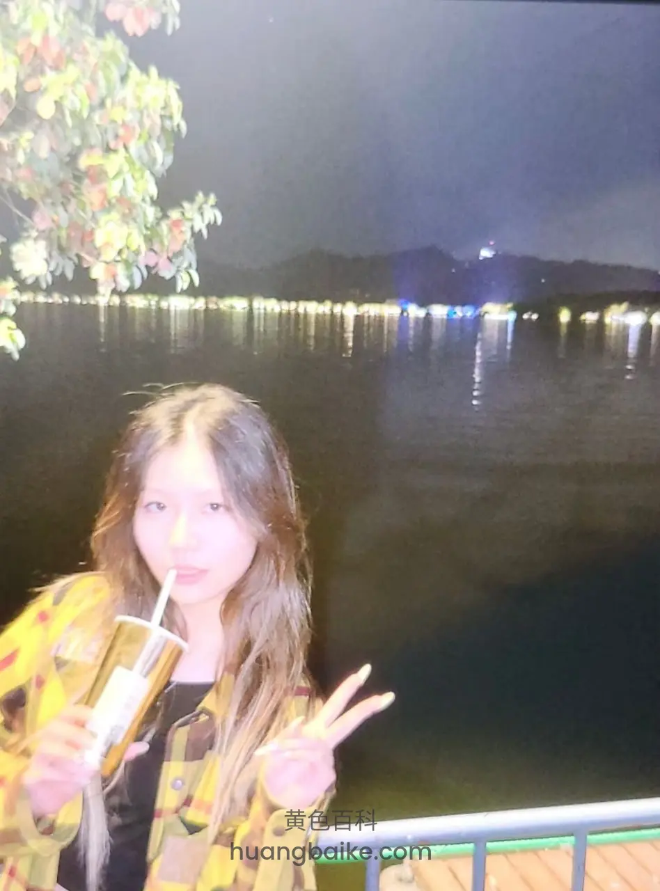 湖边夜景拿着饮料比耶