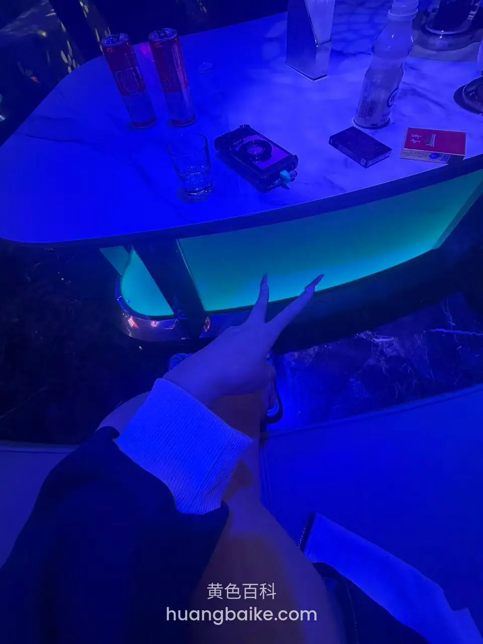 酒吧台面红牛可乐，镜头对着手比剪刀