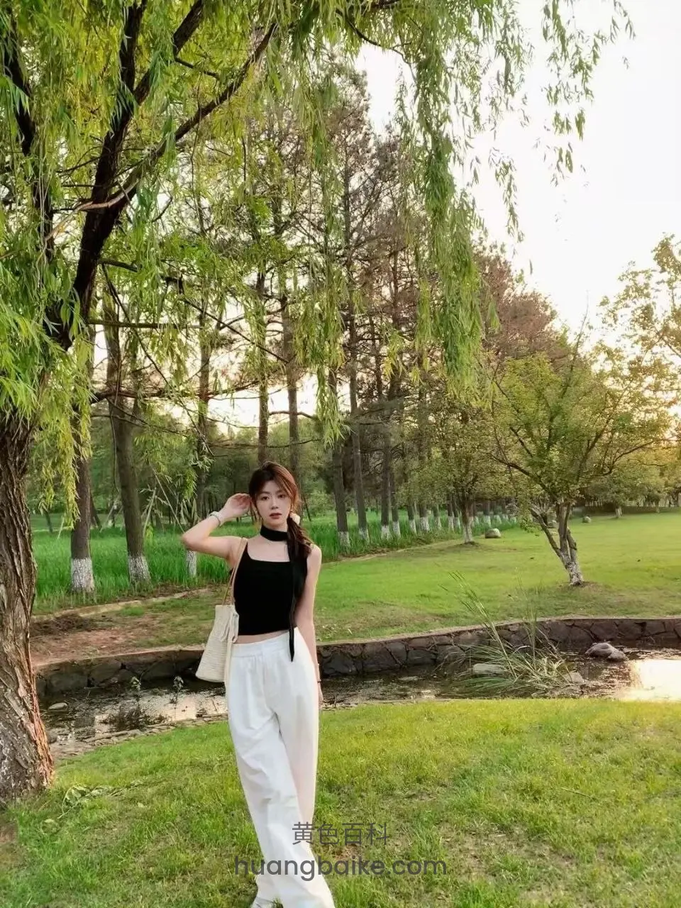 公园柳树下站立，手举到耳边