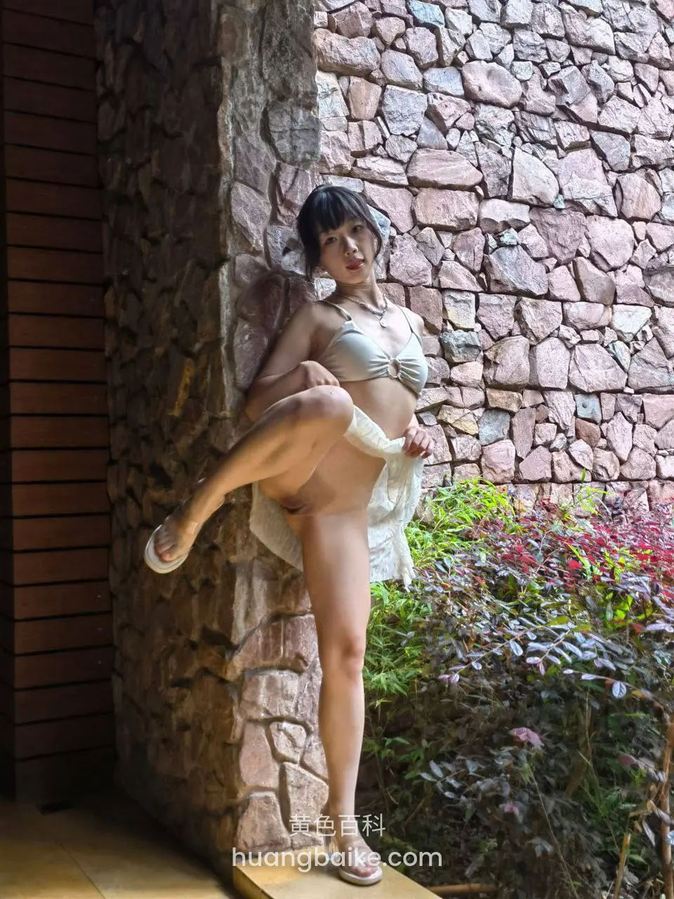 石墙边抬腿站立手拉白纱