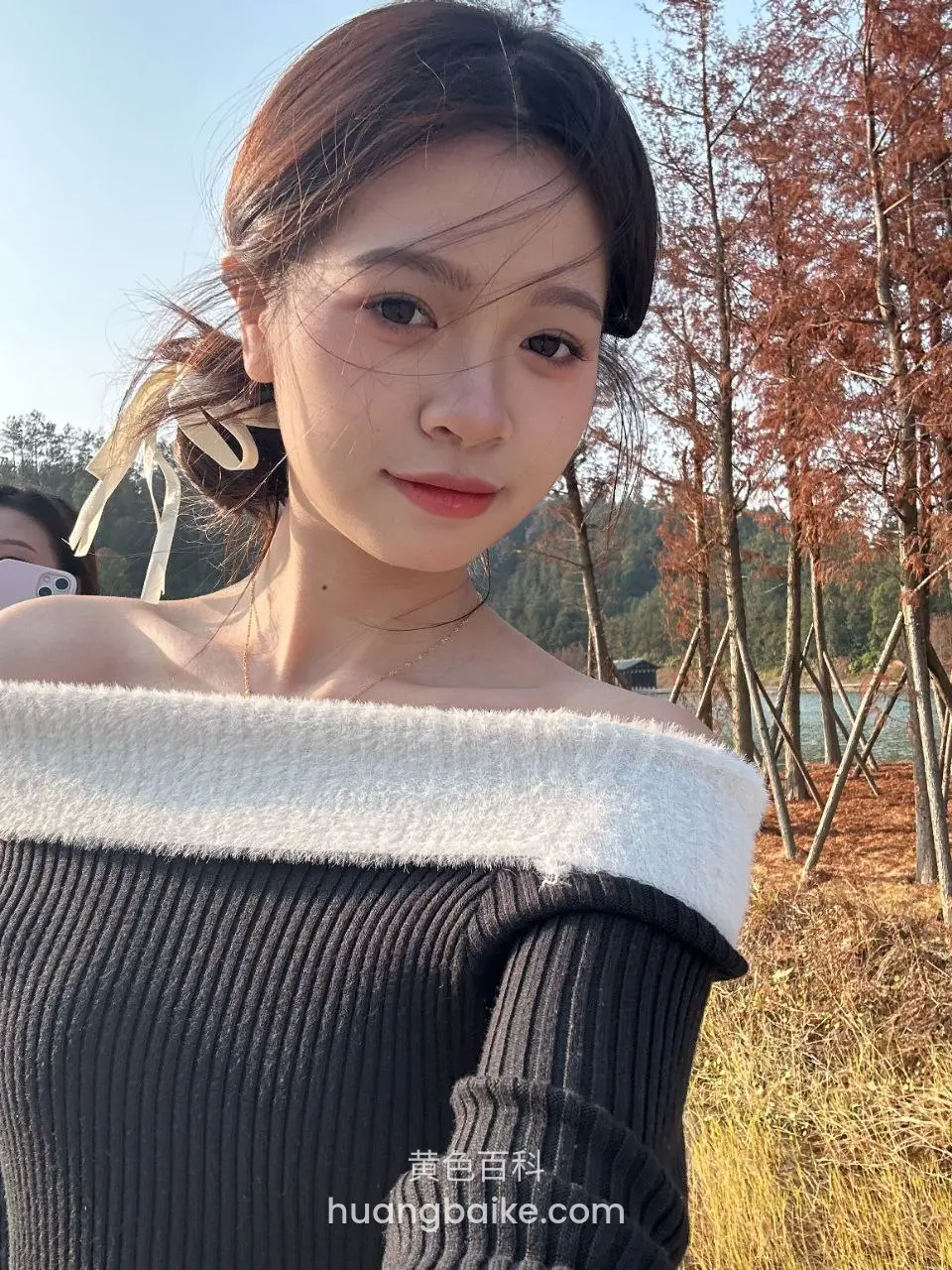 户外树林前低角度仰拍，身后是湖和树