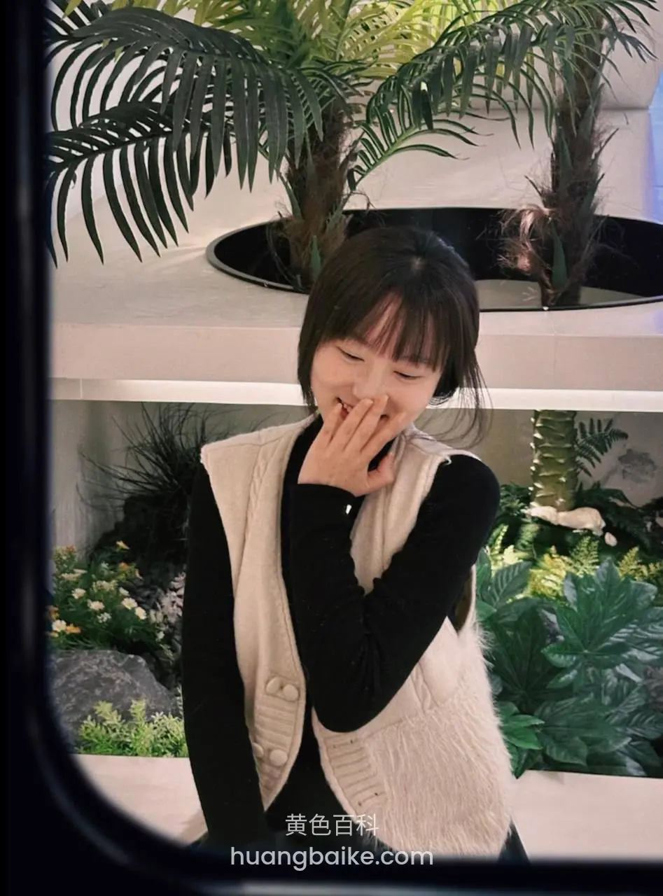 女子捂嘴笑在绿植中