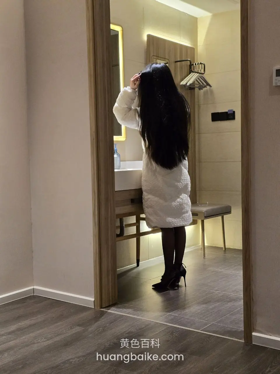 卫生间门口穿白羽绒服长发背影，手扶头发