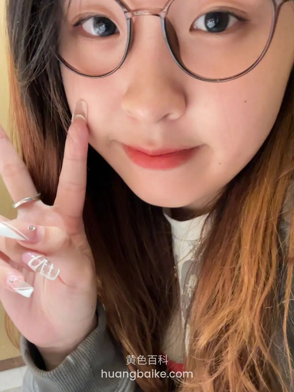 戴眼镜女生比V手秀美甲