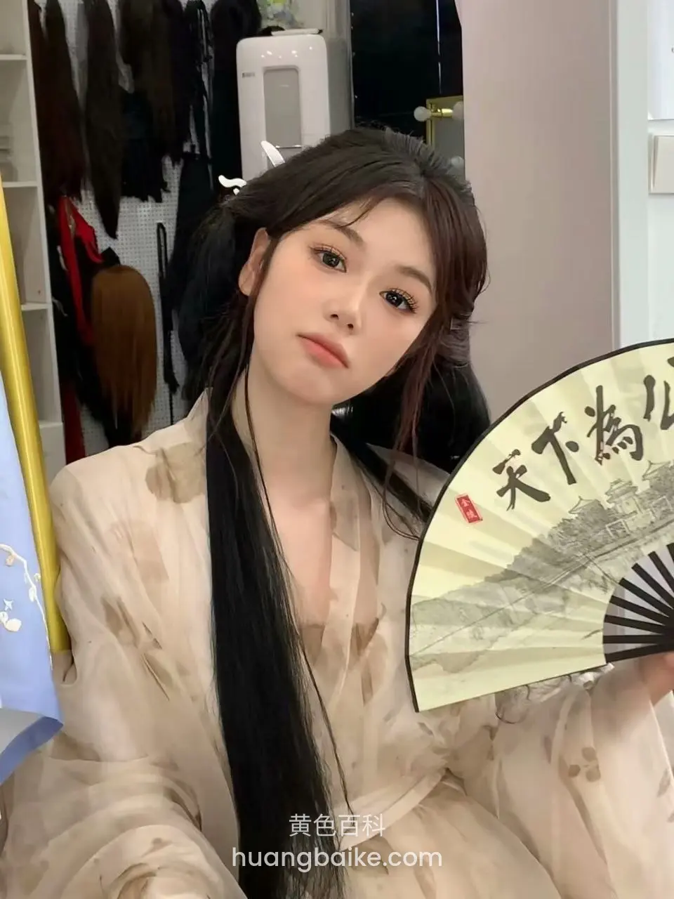房间里拿着团扇，扇上有天下为公