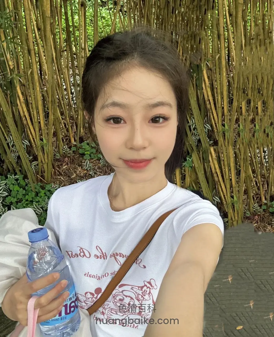拿着矿泉水瓶自拍，身后竹林