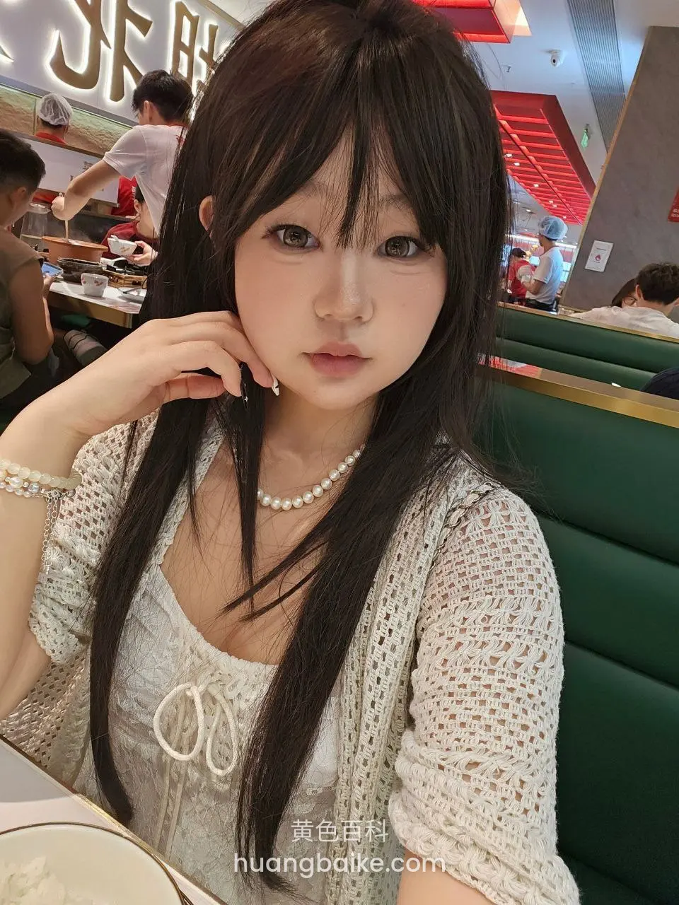 餐厅绿沙发前手托下巴看镜头
