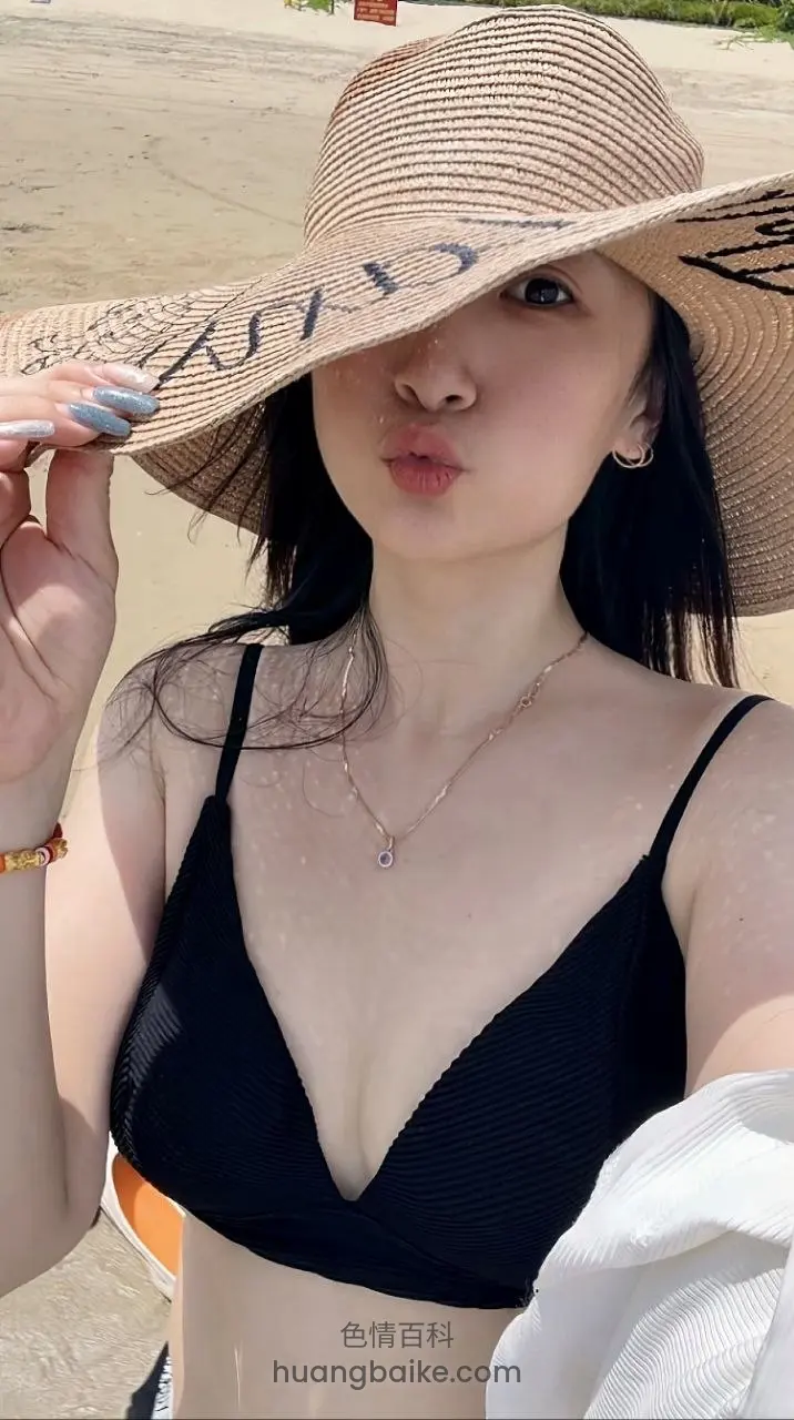 沙滩上大草帽遮脸，手指捏帽檐嘟嘴
